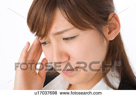 Stock Photo - A young woman suffering from headache. Fotosearch