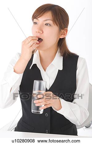 A young woman taking pills View Large Photo Image Stock Photo - A young woman taking pills. Fotosearch
