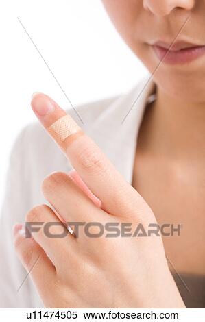Close-up of woman's finger with adhesive bandage View Large Photo Image Stock Photography - Close-up of woman's finger with adhesive bandage. Fotosearch