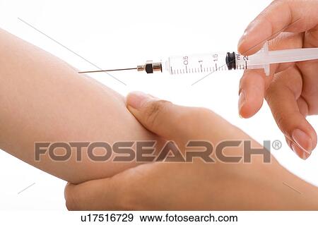 Doctor injecting arm of a woman View Large Photo Image Stock Photo - Doctor injecting arm of a woman. Fotosearch