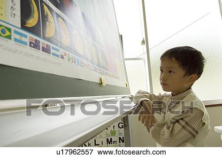 Boy looking at picture View Large Photo Image Stock Photo - Boy looking at picture. Fotosearch