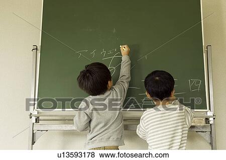 Boys writing on blackboard View Large Photo Image Stock Photo - Boys writing on blackboard. Fotosearch