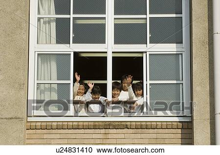 Stock Image - Children looking out of window at school. Fotosearch