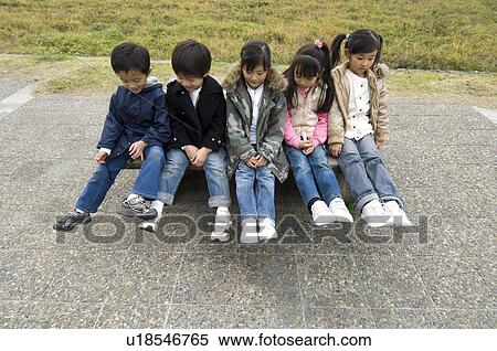 Stock Photography - Children sitting in a row. Fotosearch