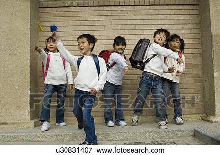Children throwing paper airplane View Large Photo Image Stock Photo - Children throwing paper airplane. Fotosearch