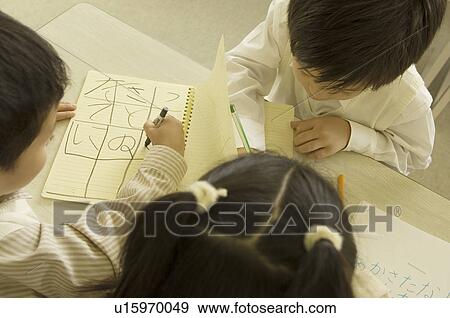 Stock Photo - Children writing on notebook. Fotosearch
