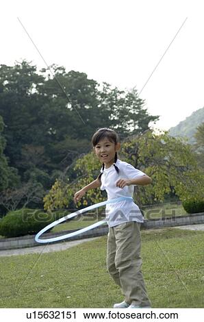 Stock Image - Girl playing with hula hoop. Fotosearch