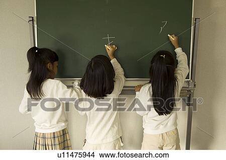 Girls writing on blackboard View Large Photo Image Picture - Girls writing on blackboard. Fotosearch