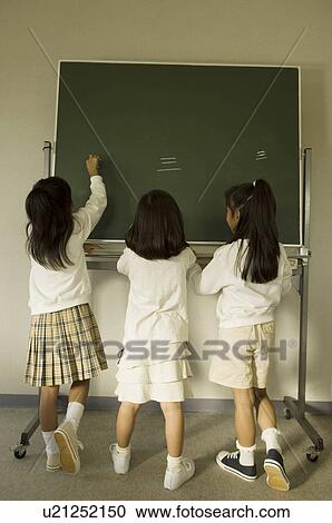 Girls writing on blackboard View Large Photo Image Stock Image - Girls writing on blackboard. Fotosearch