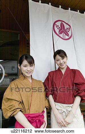 Two young women standing in front of restaurant View Large Photo Image Stock Image - Two young women standing in front of restaurant. Fotosearch