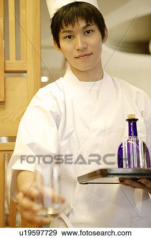Waiter holding tray of glasses and bottle View Large Photo Image Stock Photo - Waiter holding tray of glasses and bottle. Fotosearch