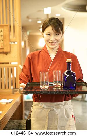 Waitress holding tray of glasses and bottle View Large Photo Image Picture - Waitress holding tray of glasses and bottle. Fotosearch