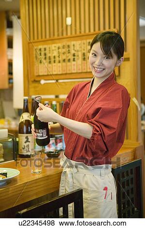 Stock Photo - Waitress opening beer bottle. Fotosearch