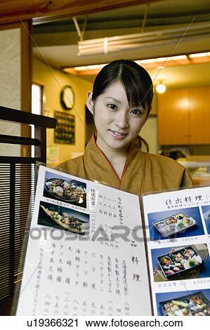 Waitress showing menu at Japanese restaurant View Large Photo Image Stock Image - Waitress showing menu at Japanese restaurant. Fotosearch