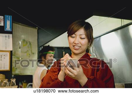 Stock Image - Waitress writing order at restaurant. Fotosearch