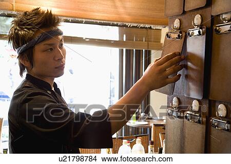 Picture - Young man touching blank order file. Fotosearch