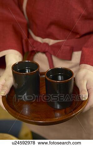 Stock Photo - Young woman carrying a tray of tea. Fotosearch