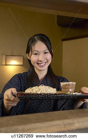 Young woman receiving a tray of noodles View Large Photo Image Stock Photo - Young woman receiving a tray of noodles. Fotosearch