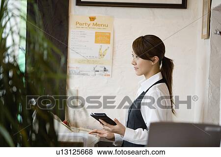 Stock Photo - Cashier at checkout counter. Fotosearch
