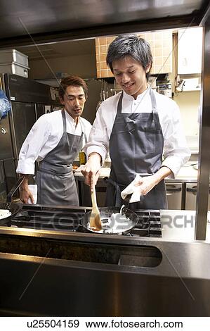 Stock Photo - Chef cooking in restaurant kitchen. Fotosearch