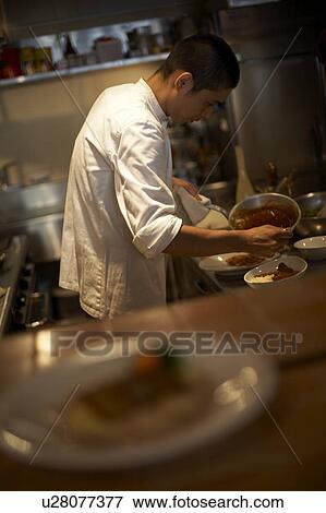 Stock Photo - Chef cooking in restaurant kitchen. Fotosearch