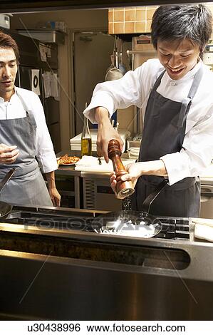 Stock Photograph - Chef cooking in restaurant kitchen. Fotosearch