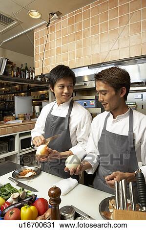 Stock Image - Two chefs peeling onion. Fotosearch