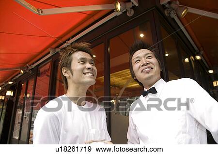 Stock Photo - Two waiters standing in front of coffee shop. Fotosearch