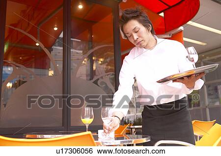 Stock Photograph - Waiter cleaning table. Fotosearch