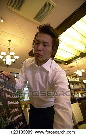 Stock Photo - Waiter holding menu board. Fotosearch