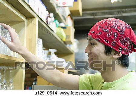 Picture - Waiter taking glass from shelf. Fotosearch