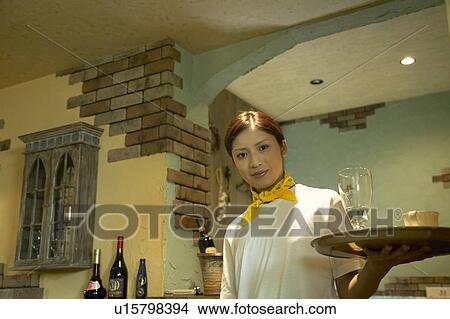 Picture - Waitress carrying drinks on tray. Fotosearch