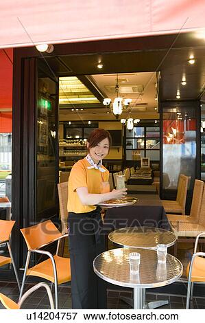 Waitress carrying drinks on tray View Large Photo Image Stock Photo - Waitress carrying drinks on tray. Fotosearch