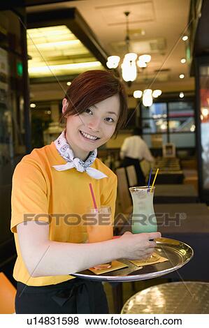 Stock Photo - Waitress carrying drinks on tray. Fotosearch