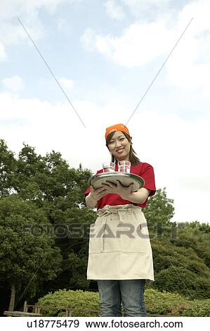 Stock Photo - Waitress carrying drinks on tray. Fotosearch
