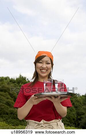 Waitress carrying drinks on tray View Large Photo Image Stock Photo - Waitress carrying drinks on tray. Fotosearch