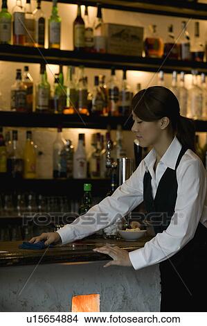 Picture - Waitress cleaning bar counter. Fotosearch