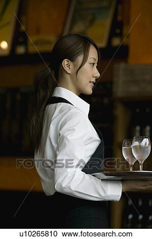 Stock Image - Waitress holding tray with glasses of water. Fotosearch