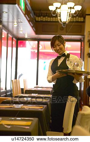 Stock Image - Waitress holding tray with glasses of water. Fotosearch