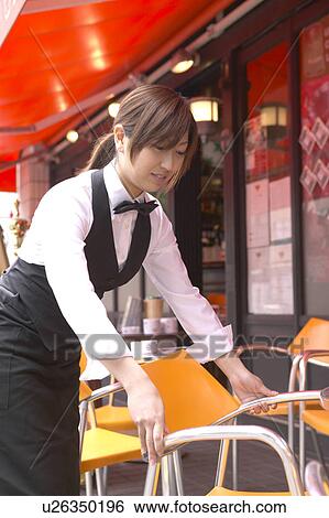 Stock Photograph - Waitress setting table. Fotosearch