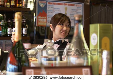 Stock Photography - Waitress standing behind bar counter. Fotosearch