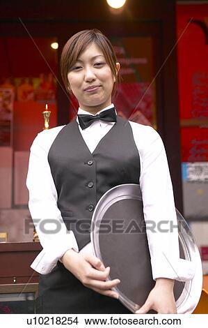 Picture - Waitress standing in front of coffee shop. Fotosearch