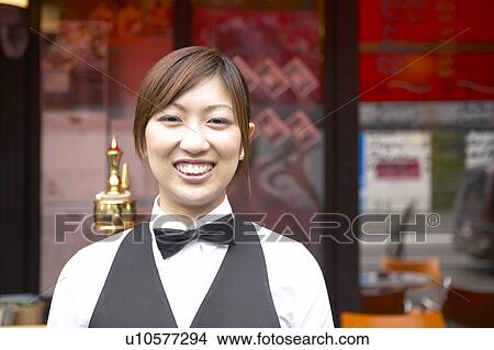 Picture - Waitress standing in front of coffee shop. Fotosearch