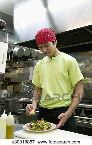 Young man making salad View Large Photo Image Stock Photo - Young man making salad. Fotosearch