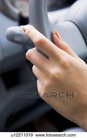 Stock Photo - Close-up of woman's hand on wheel. Fotosearch