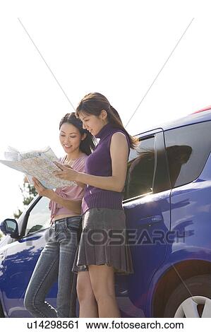 Stock Image - Two young women looking at map. Fotosearch
