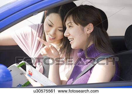 Stock Image - Two young women looking at map. Fotosearch