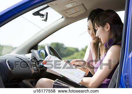 Stock Photo - Two young women looking at map. Fotosearch