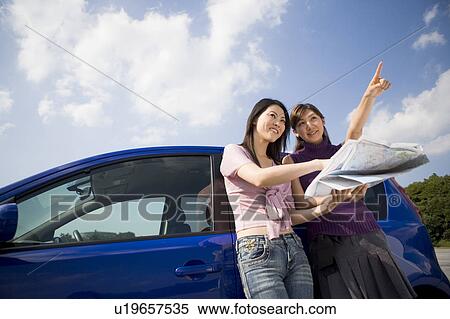 Stock Photography - Two young women looking at map. Fotosearch