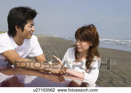 Young couple standing on beach View Large Photo Image Stock Image - Young couple standing on beach. Fotosearch